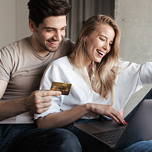 Kreditkartenvergleich: Junges Paar mit Laptop auf dem Sofa