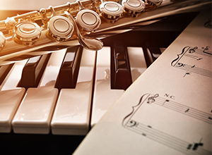Musikinstrumentenversicherung: Klavier, Saxophone und Notenblatt
