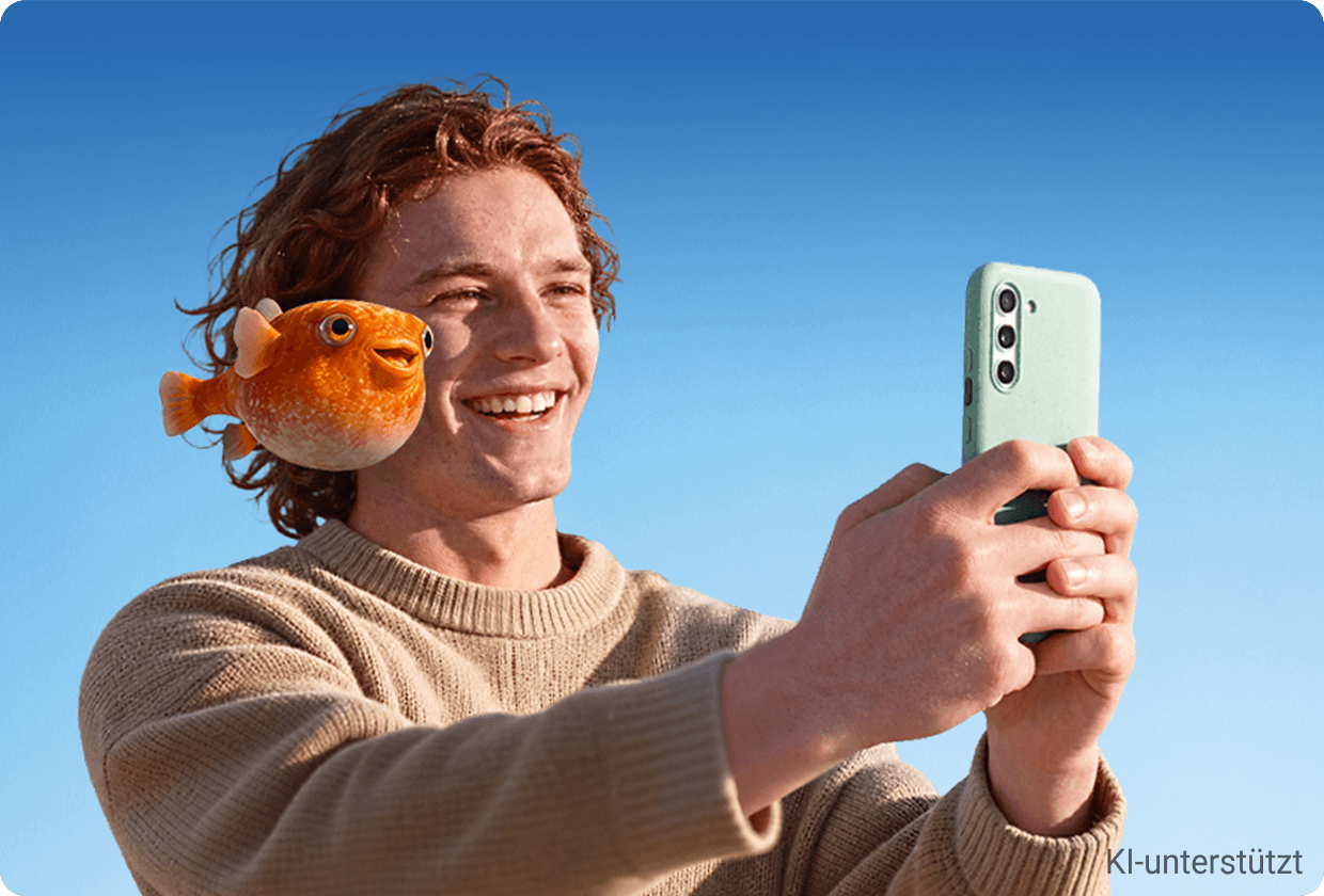 Junger Mann, der lächelnd mit gestreckten Armen sein Handy anschaut, über seiner Schulter fliegt ein lächelnder Fisch