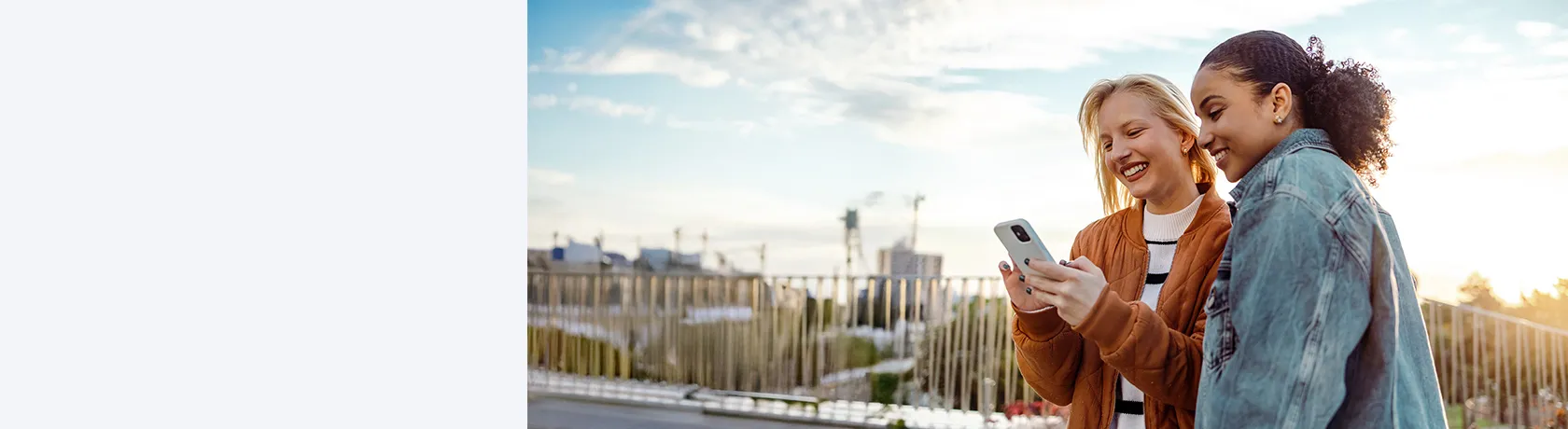 Zwei Frauen auf Dachterrasse mit Handy