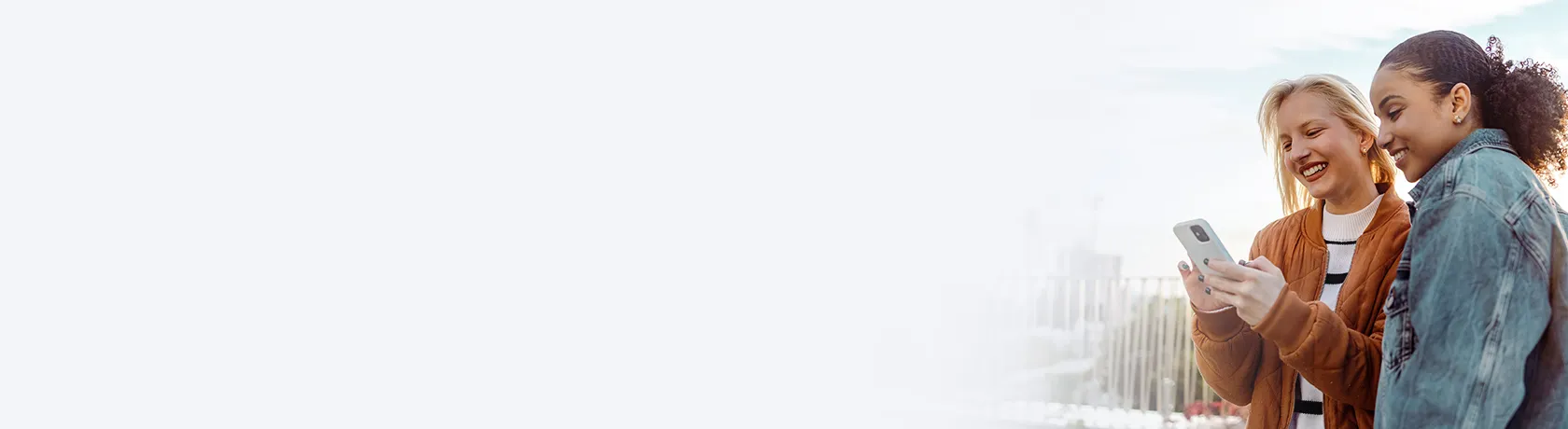 Zwei Frauen auf Dachterrasse mit Handy