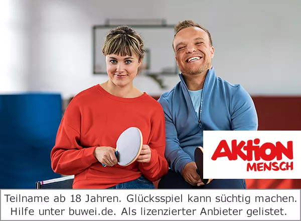 Eine Frau und ein Mann sitzen auf einer Tischtennisplatte nebeneinander und haben jeweils einen Tischtennisschläger in ihrer Hand. Im Hintergrund ist eine Sporthalle zu sehen.