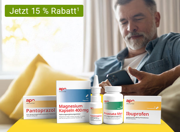 Arzneimittelpackungen auf einem Tisch, ein Mann sitzt auf einem Sofa und hält ein Smartphone.