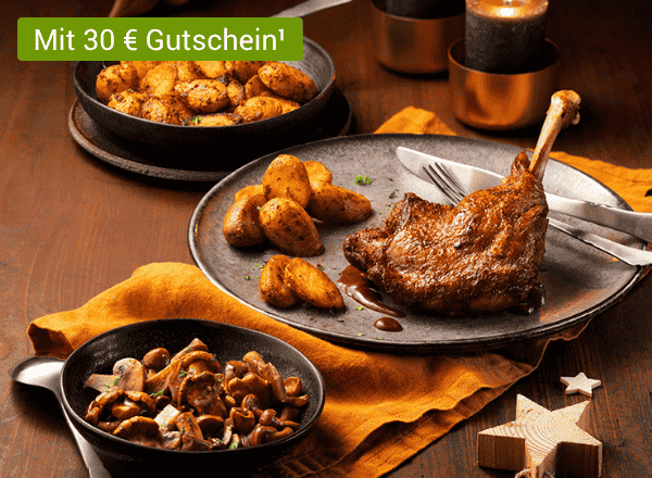 Gebratene Gänsekeule mit Bratkartoffeln und Pilzen auf festlich gedecktem Tisch.