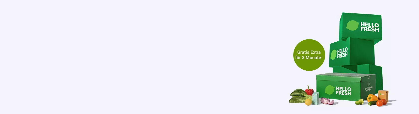 Drei grüne HelloFresh-Lieferboxen gestapelt mit einer weiteren Box im Vordergrund, daneben frisches Gemüse und Obst.