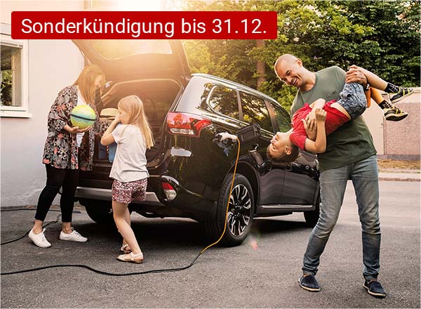 Ein Auto mit geöffnetem Kofferraum steht vor einem Haus. Eine Familie steht vor dem Auto. Die Mutter lädt Gepäck in den Kofferraum, ein Kind steht daneben. Der Vater steht scherzend mit einem weiteren Kind neben dem Fahrzeug.