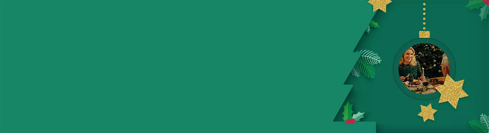 Vier Personen feiern fröhlich beim Weihnachtsessen mit Wein und festlich gedecktem Tisch.