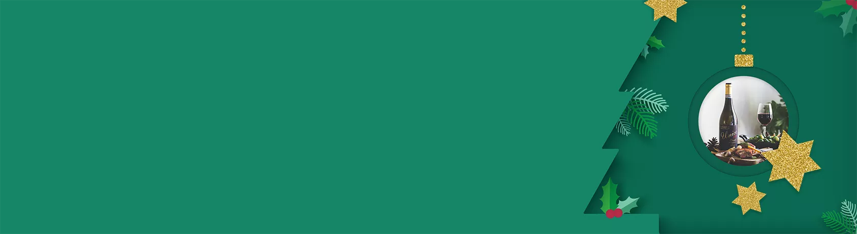 Flasche Rotwein mit goldener Kapsel und schwarzem Etikett 'Unico', daneben Weinglas mit Rotwein, grüne Trauben und Tannenzapfen auf Tisch.