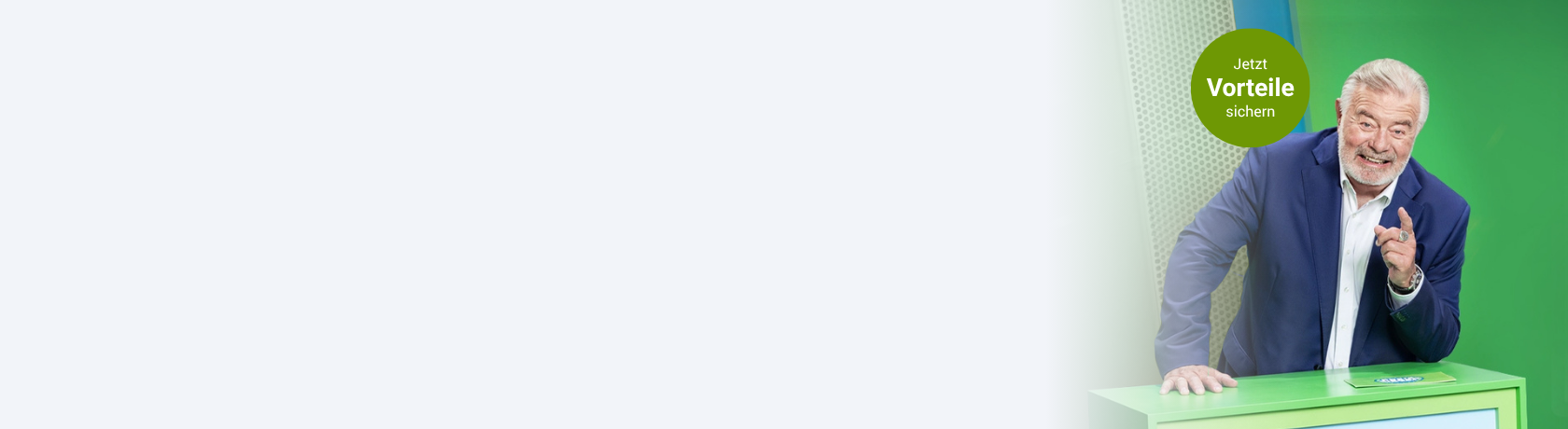 Älterer Mann im dunkelblauen Anzug stützt sich lachend auf grünes Pult und zeigt mit dem Zeigefinger auf sein Gegenüber.