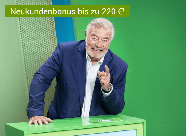 Älterer Mann im dunkelblauen Anzug stützt sich lachend auf grünes Pult und zeigt mit dem Zeigefinger auf sein Gegenüber.