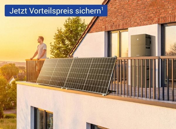 Ein Mann steht auf einem Balkon, vor ihm ist ein Balkonkraftwerk mit Solarpaneelen installiert, an der Hauswand befindet sich ein moderner Stromspeicher bei warmem Abendlicht.
