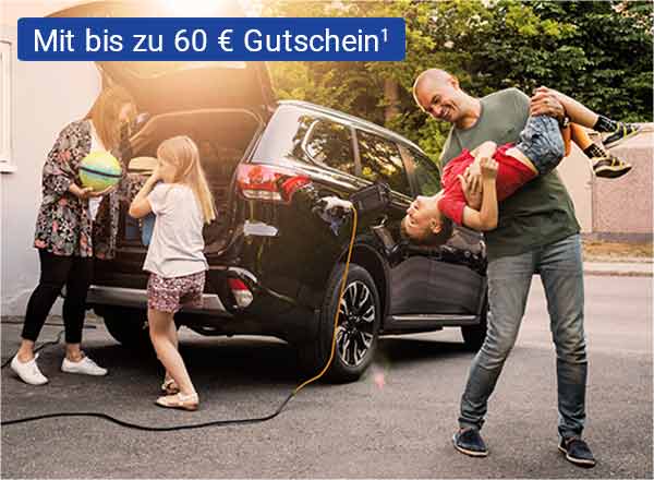 Ein Auto mit geöffnetem Kofferraum steht vor einem Haus. Eine Familie steht vor dem Auto. Die Mutter lädt Gepäck in den Kofferraum, ein Kind steht daneben. Der Vater steht scherzend mit einem weiteren Kind neben dem Fahrzeug.