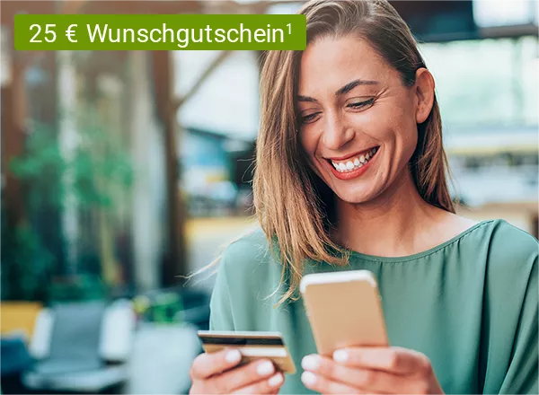Eine lächelnde Frau mit einem silbernen Smartphone in der linken und einer Kreditkarte in der rechten Hand. Im Hintergrund befindet sich ein Shoppingcenter und im Vordergrund wird ein 25 € Shoppinggutschein von Wunschgutschein abgebildet.