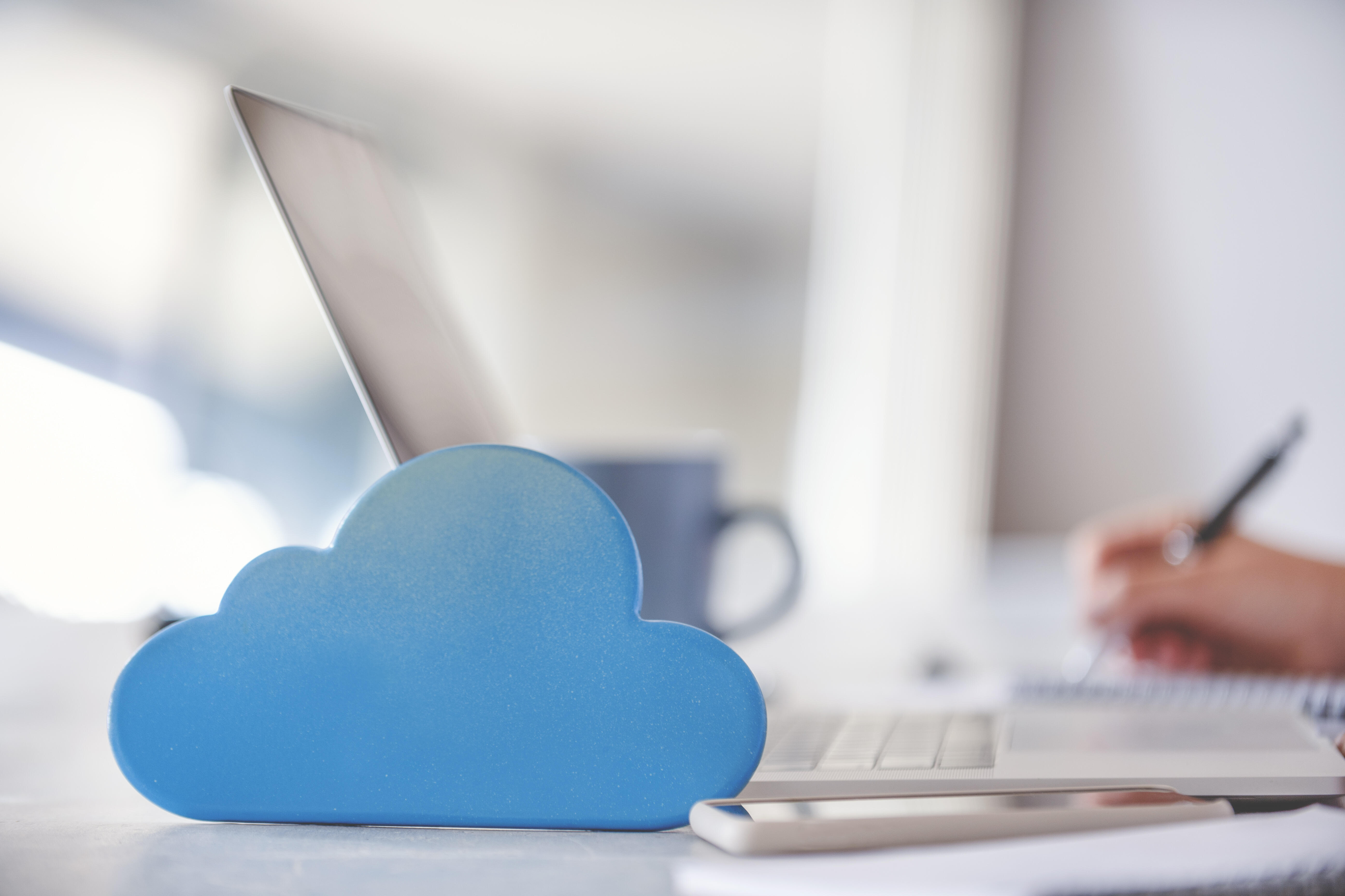 Cloud image next to smartphone and laptop with woman’s hands