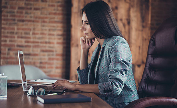 Side view of young businesswoman working on laptop