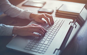 Woman’s hands typing on computer keyboard