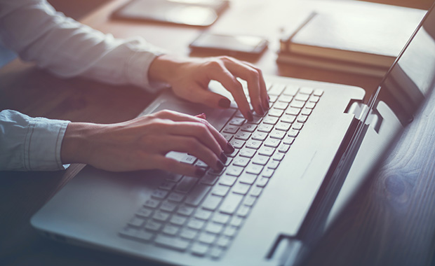 Woman’s hands typing on computer keyboard