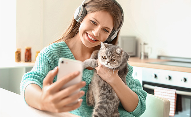 Woman holding cat takes selfie