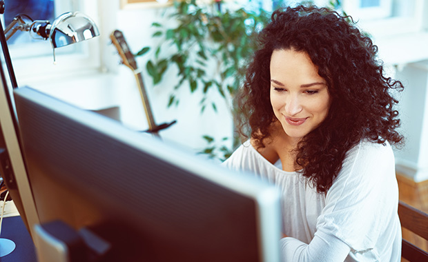 Smiling woman working on computer at home