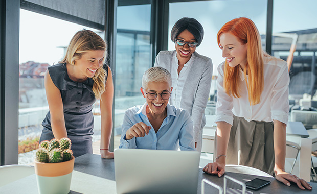 Four women in office looking at computer