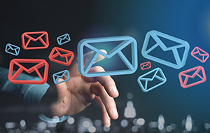 Hand pointing at floating red and blue email icons