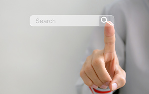 A person’s finger is touching a floating digital search bar.