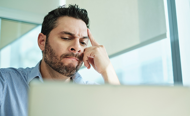 Angry man looks at computer screen