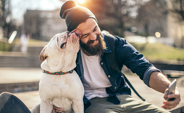Smiling bearded man takes selfie with his dog