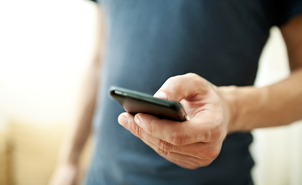 Close-up of man’s hand holding smartphone