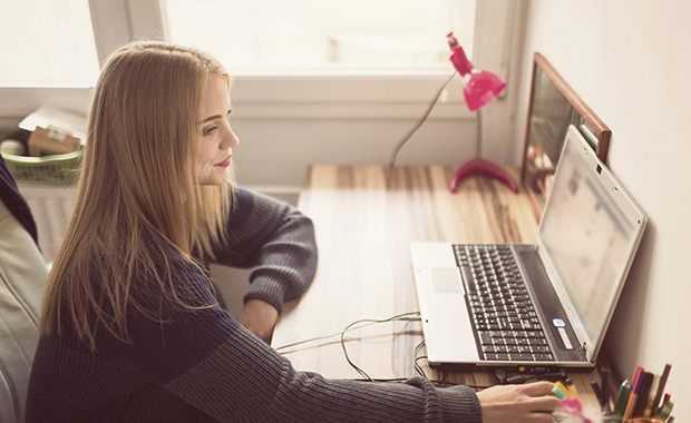 Young woman working at desk on computer
