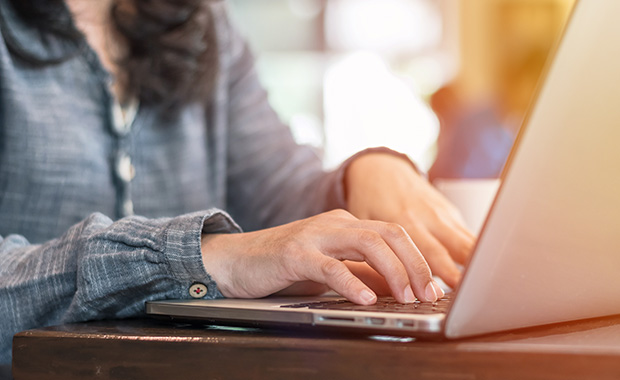 Woman’s hands typing on laptop