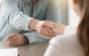 Business agreement handshake of man and woman at the office