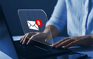 Hands typing on a laptop showing an email program