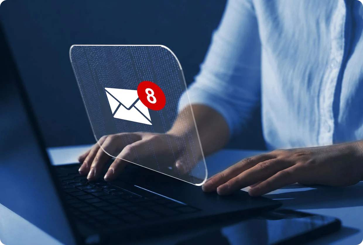 Hands typing on a laptop showing an email program