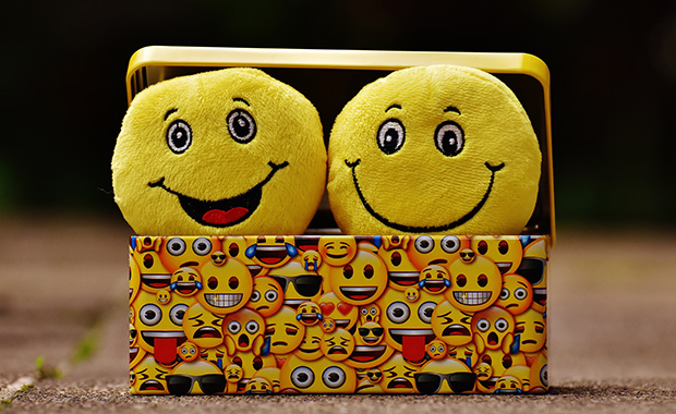 Two smileys in box covered with emoji images