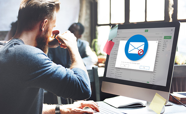 Man drinking coffee and looking at computer screen with spam email 