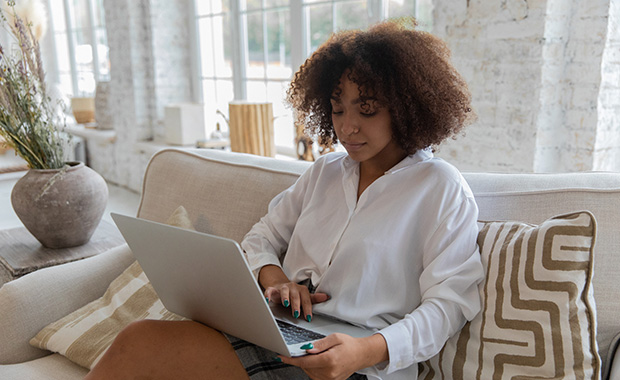 Woman sitting on couch with laptop