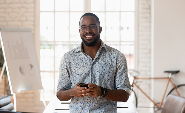 Smiling man holding smartphone