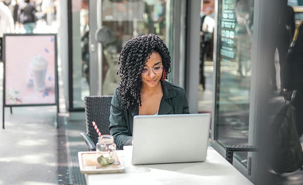 Woman with laptop at table outside café