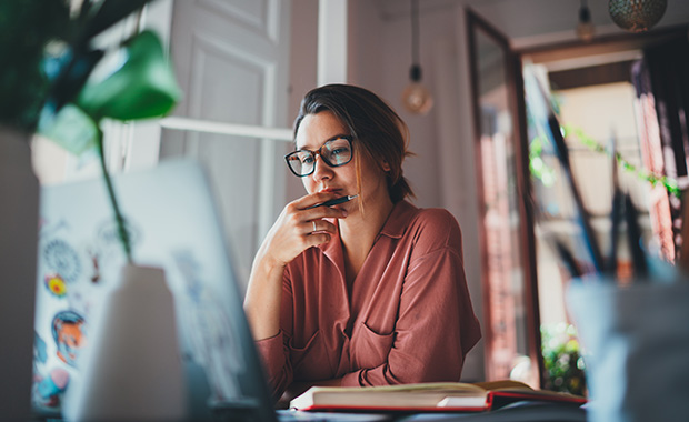 Young woman sits at desk using computer