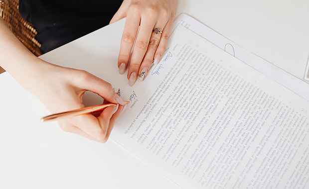 Woman’s hands signing document with pen