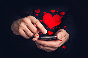 Man’s hands typing love messages on a smartphone