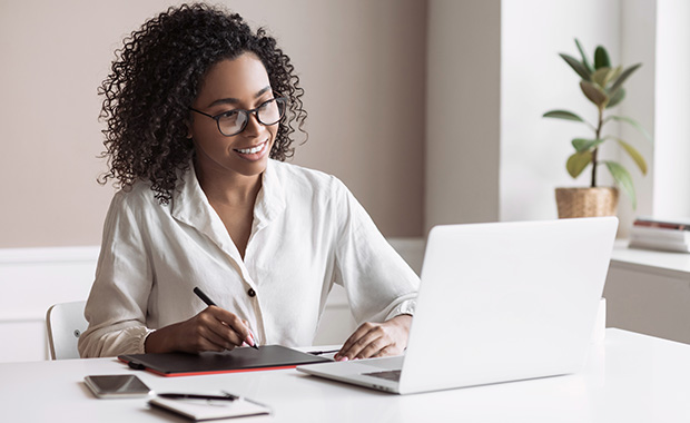 Smiling professional woman participates in video call on laptop