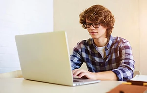 Student typing on a laptop at a desk