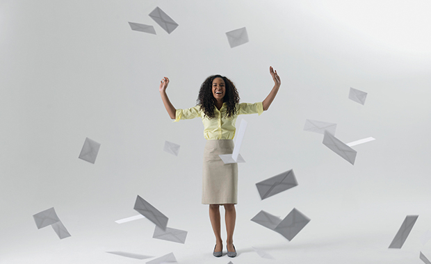 Young businesswoman blocking flying envelopes