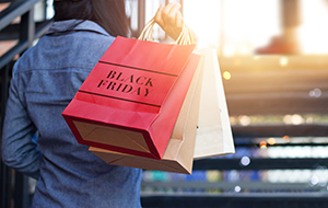 Back view of woman holding shopping bag with the words Black Friday