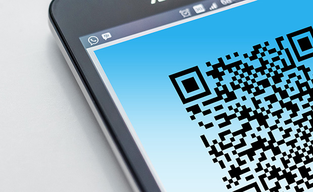 Corner of mobile device with screen displaying part of a QR code