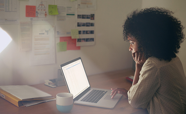 Young women sitting in dark office working on laptop