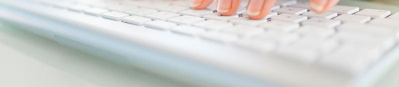 White keyboard with woman's fingers typing