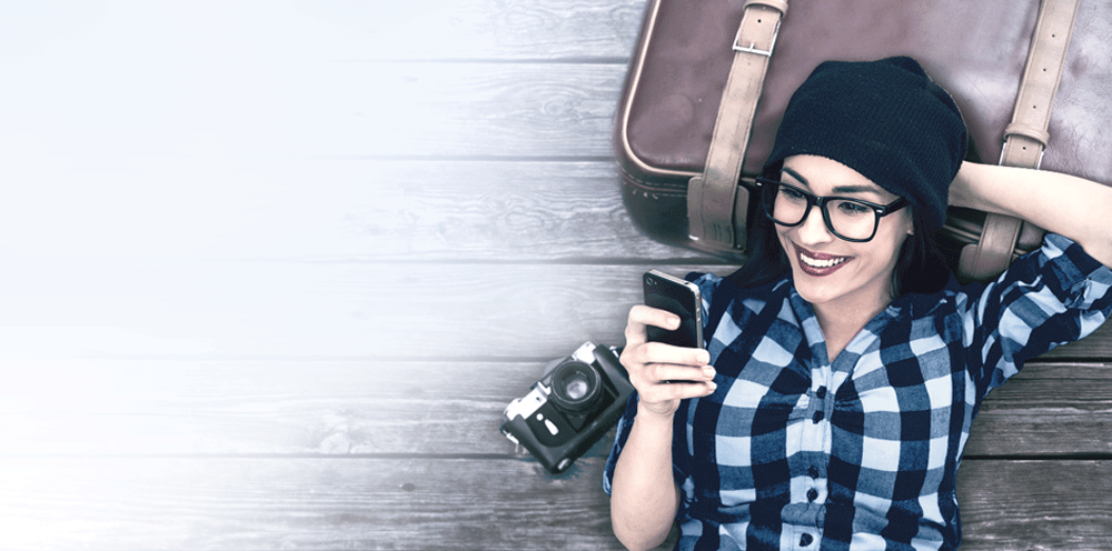 smiling woman watching her photos on mail.com cloud within her smartphone